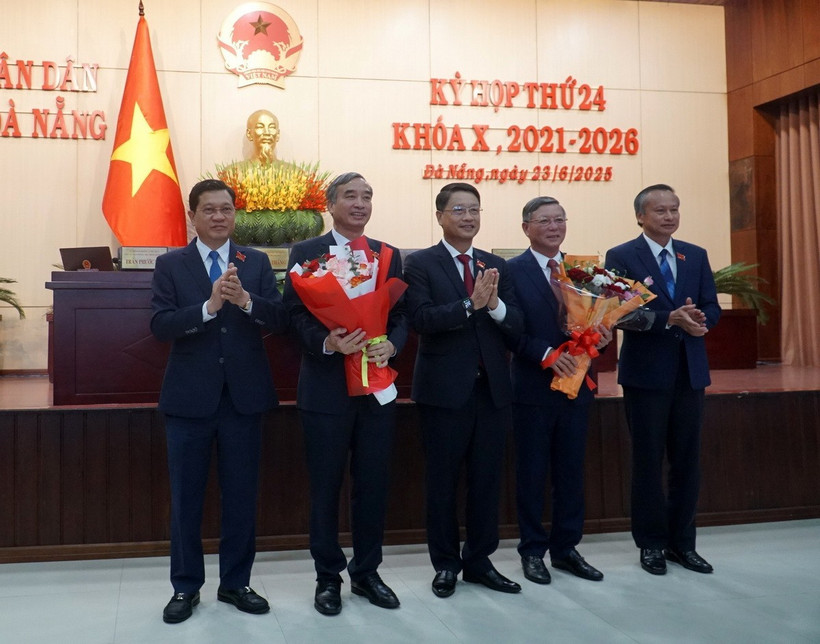 Chủ tịch Ủy ban Nhân dân thành phố Đà Nẵng Lê Trung Chinh (thứ hai từ trái sang) và Chủ tịch Ủy ban Mặt trận Tổ quốc Việt Nam thành phố Đà Nẵng Lê Văn Trung (thứ từ từ trái sang) nhận hoa chúc mừng của Thường trực Hội đồng Nhân dân thành phố Đà Nẵng. (Ảnh: Quốc Dũng/TTXVN)