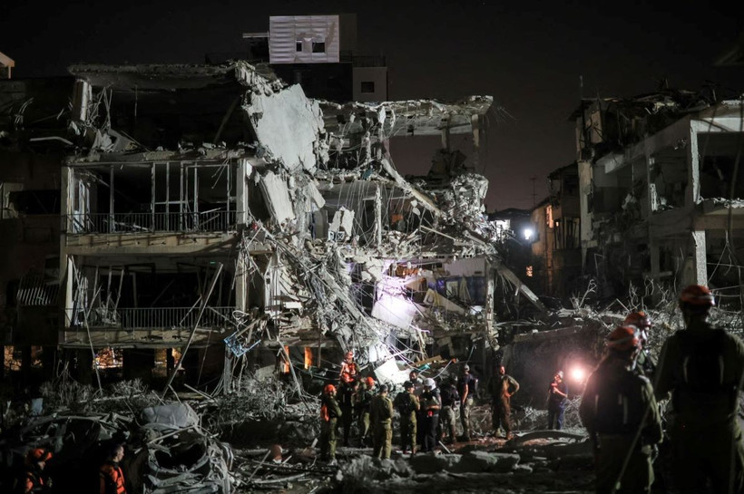 Lực lượng cứu hộ làm nhiệm vụ tại hiện trường đổ nát sau loạt vụ phóng kích của Iran xuống Ramat Gan, Israel ngày 13/6/2025. (Ảnh: Reuters/TTXVN)