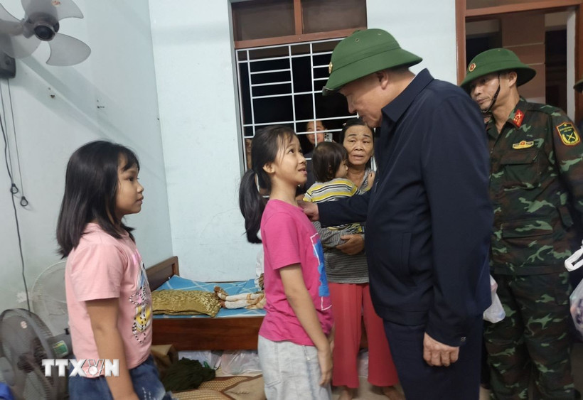 Phó Thủ tướng Thường trực Nguyễn Hòa Bình động viên các cháu học sinh được các lực lượng ứng cứu từ vùng ngập sâu. (Ảnh: Tuấn Anh/TTXVN)