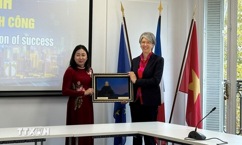 Bà Đinh Thị Lụa (trái) tặng quà cho bà Géraldine Lemblé - Phó Tổng giám đốc Liên đoàn Doanh nghiệp Pháp. (Ảnh: Đào Dũng/TTXVN)