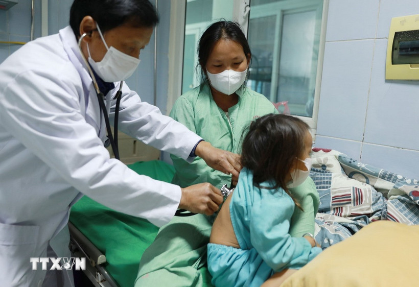 Bác sỹ thăm khám bệnh nhi mắc bệnh sởi. (Ảnh: Quý Trung/TTXVN)