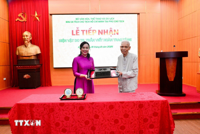 Ông Trần Viết Hoàn - cận vệ của Bác Hồ, nguyên Giám đốc Khu Di tích Chủ tịch Hồ Chí Minh tại Phủ Chủ tịch trao tặng hiện vật chiếc máy chữ cho Khu Di tích. (Ảnh: TTXVN phát)