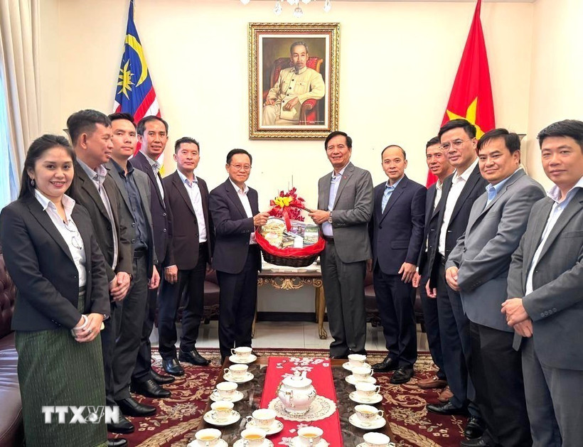 Đại sứ Thepthavone dẫn đầu đoàn Đại sứ quán Lào tặng quà chúc mừng Đại sứ Đinh Ngọc Linh và cán bộ, nhân viên Đại sứ quán Việt Nam. (Ảnh: Viên Luyến/TTXVN)