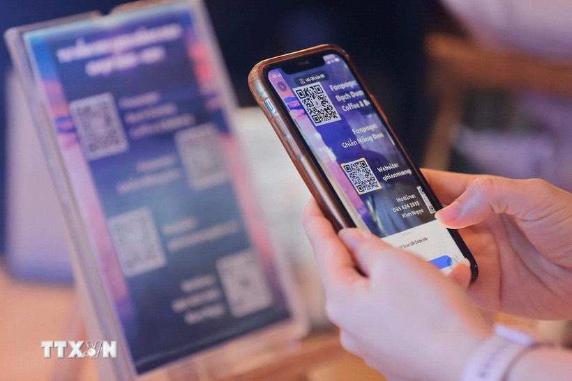 Du khách sử dụng điện thoại thông minh quét mã QR Code tìm kiếm thông tin về các điểm du lịch, điểm tham quan, ẩm thực… (Ảnh: Minh Quyết/TTXVN)