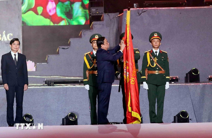 Phó Chủ tịch Quốc hội Lê Minh Hoan gắn Huân chương Lao động hạng Nhất lên cờ truyền thống của tỉnh Sơn La. (Ảnh: Quang Quyết/TTXVN)