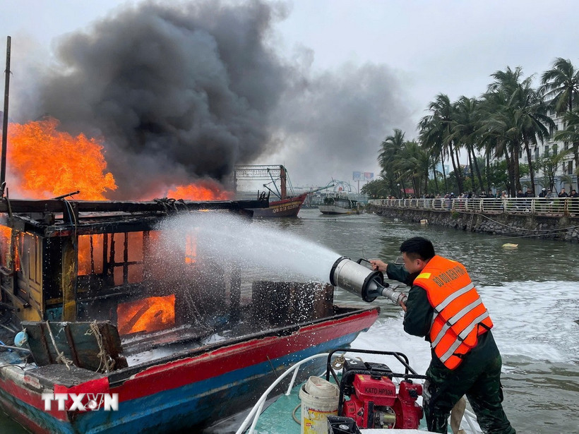 Lực lượng chức năng nỗ lực khống chế tàu cá bị cháy. (Ảnh: TTXVN phát)