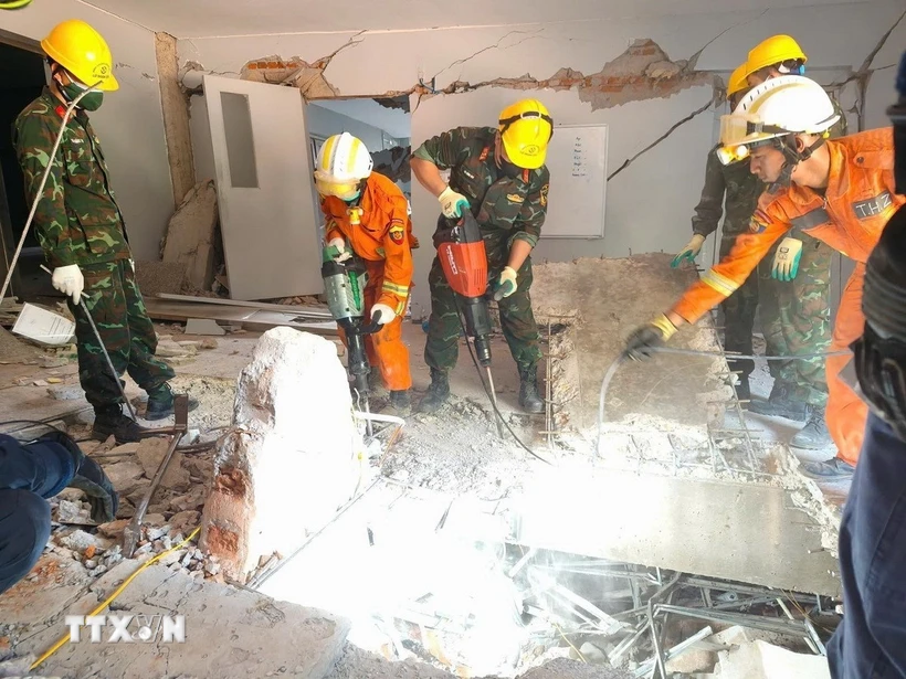 Đội công binh của đoàn Quân đội Nhân dân Việt Nam và lực lượng cứu hộ của Myanmar, UAE đục bêtông để mở lối xuống tiếp cận vị trí các nạn nhân bị vùi lấp. (Ảnh: TTXVN phát)