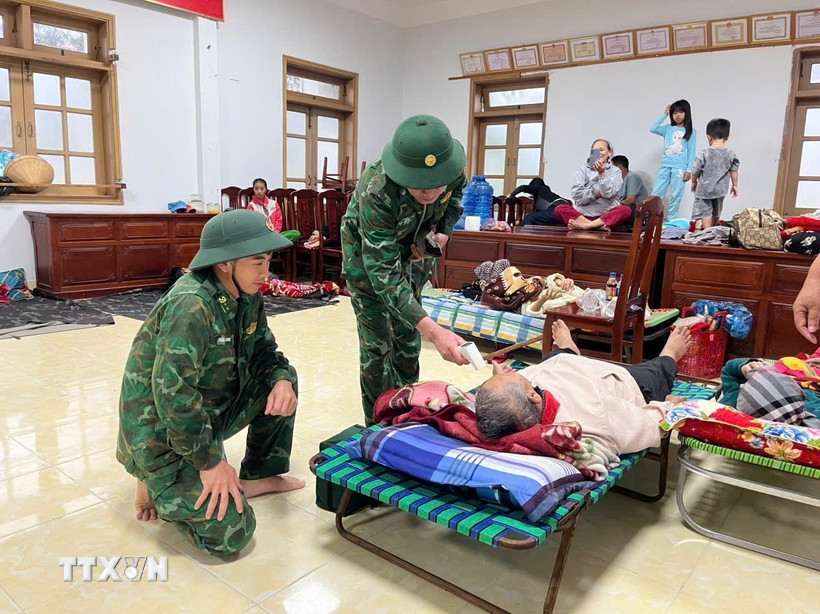 Cán bộ, chiến sỹ Đồn Biên phòng Xuân Hòa theo dõi sức khỏe người dân đang tránh trú bão. (Ảnh: TTXVN phát)