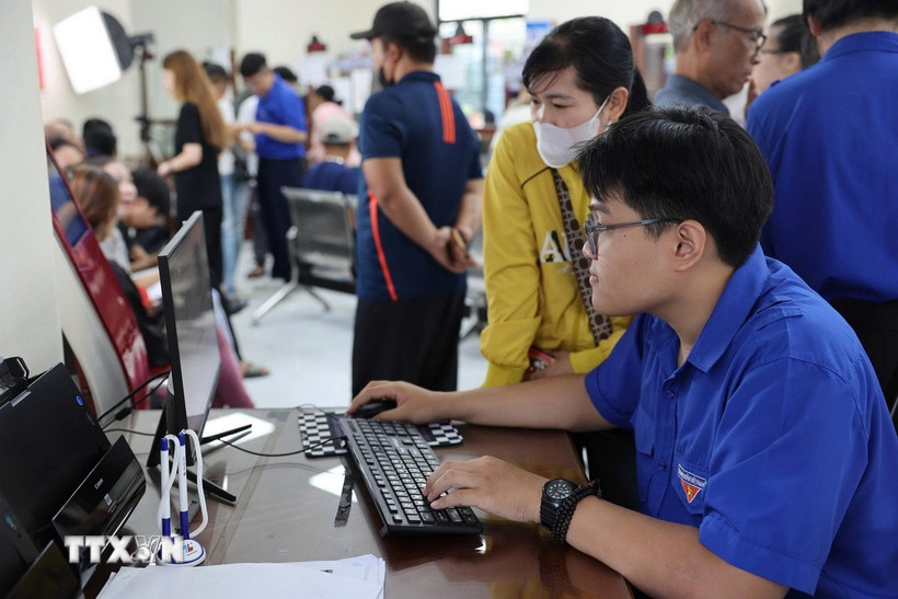 Tình nguyện viên tận tình hướng dẫn người dân nộp hồ sơ trực truyến tại Trung tâm phục vụ hành chính công phường Bà Rịa, Thành phố Hồ Chí Minh). (Ảnh: Huỳnh Sơn/TTXVN)