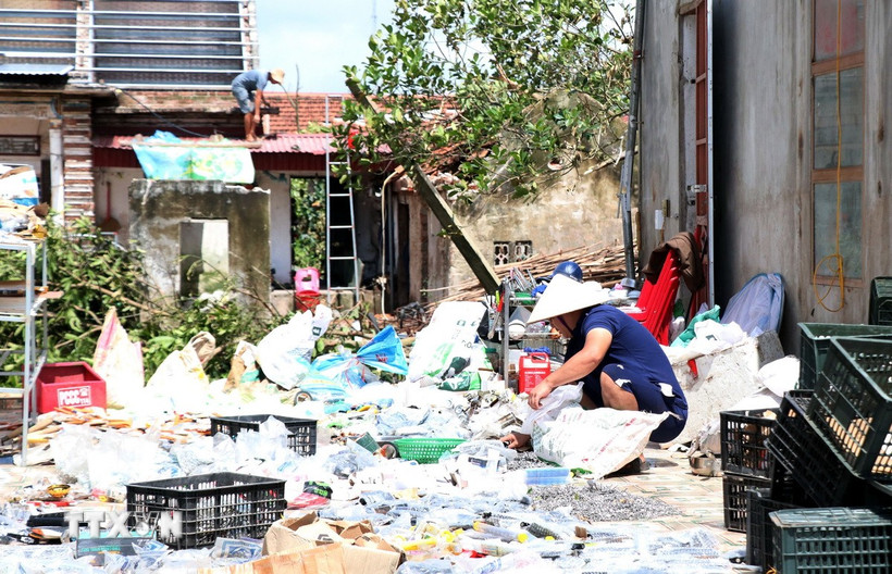 Người dân xã Quỹ Nhất, tỉnh Ninh Bình dọn dẹp đồ đạc sau dông lốc. (Ảnh: Nguyễn Lành/TTXVN)