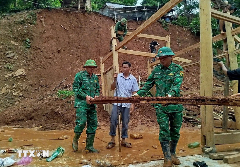 Chiến sỹ Đồn biên phòng Mỹ Lý giúp người dân địa phương khắc phục hậu quả mưa lũ. (Ảnh: TTXVN phát)