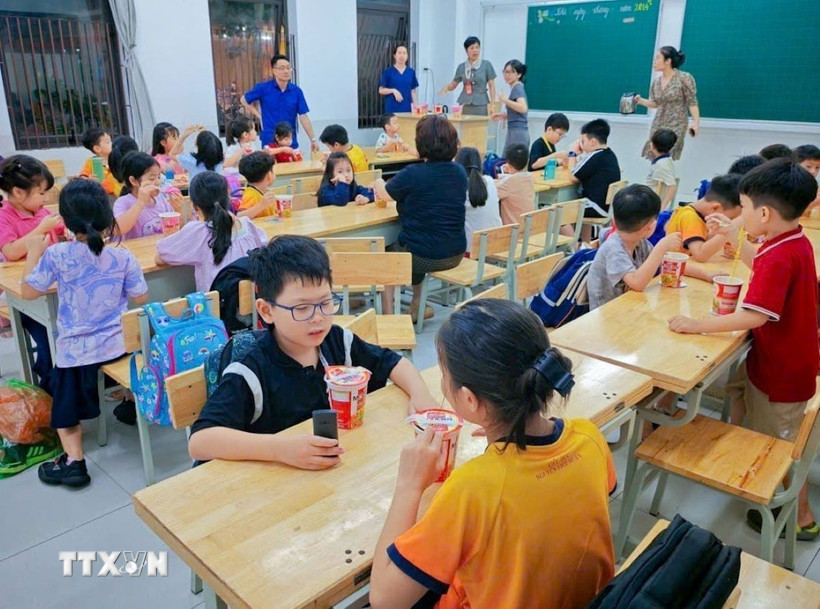 Trường Tiểu học Nguyễn Viết Xuân bố trí bữa ăn cho học sinh khi chưa có bố mẹ đón về. (Ảnh: TTXVN phát)