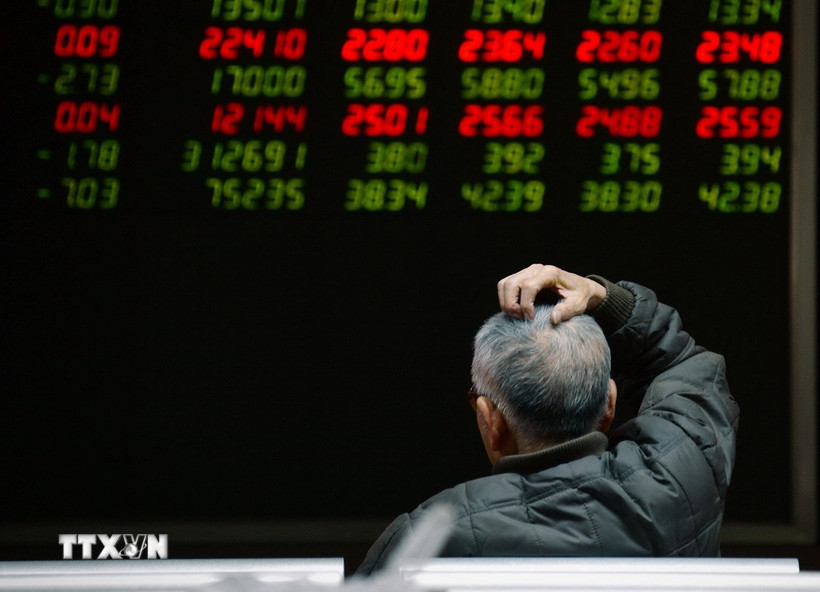 Nhà đầu tư theo dõi bảng chỉ số chứng khoán tại Bắc Kinh, Trung Quốc. (Ảnh minh họa. AFP/TTXVN)