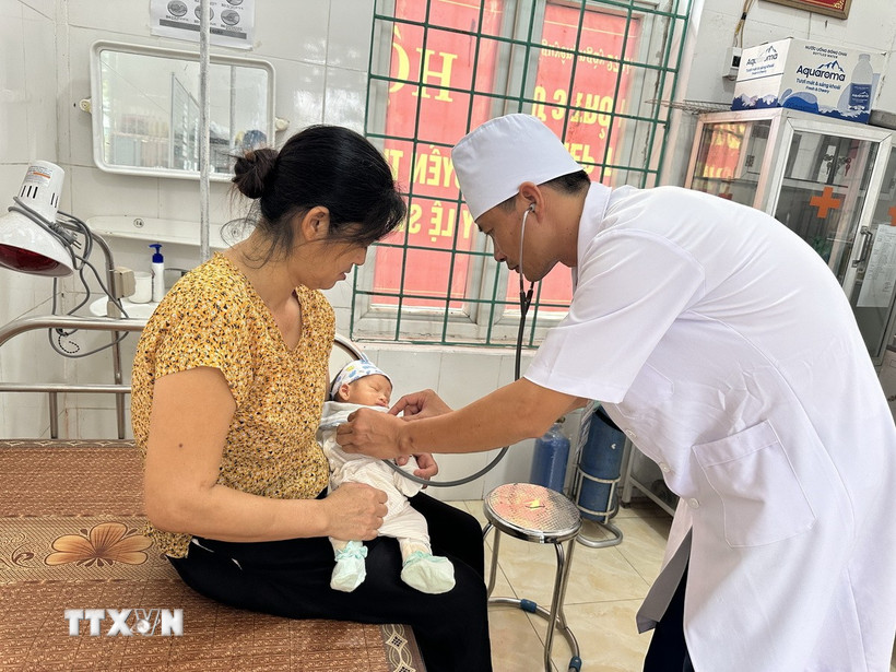 Bác sỹ Trạm y tế Trung Nguyên, xã Tề Lỗ (Phú Thọ) khám cho bệnh nhi. (Ảnh: Nguyễn Thảo/TTXVN)