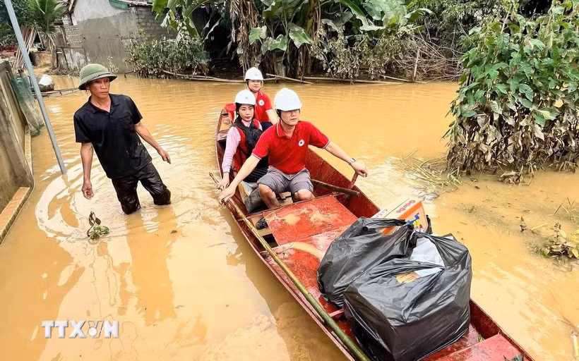 Đoàn công tác của Trung ương Hội Chữ thập Đỏ Việt Nam vượt qua những tuyến đường ngập lụt, mang hàng cứu trợ khẩn cấp đến với người dân xã Nhân Hòa (Nghệ An) - nơi đang chịu thiệt hại nặng nề do hoàn lưu bão số 3 (Wipha). (Ảnh: TTXVN phát)