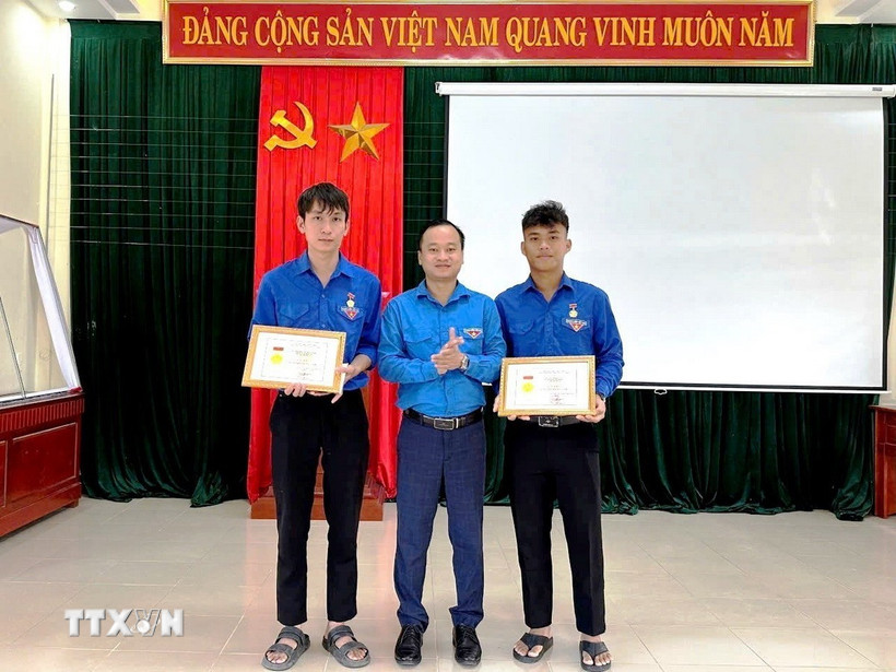 Thừa ủy quyền của Ban Bí thư Trung ương Đoàn, Phó Bí thư Tỉnh đoàn Quảng Trị Nguyễn Quốc Toản trao tặng Huy hiệu “Tuổi trẻ dũng cảm” cho đoàn viên Võ Hoàng Vũ và Nguyễn Võ Huy Công. (Ảnh: TTXVN phát)