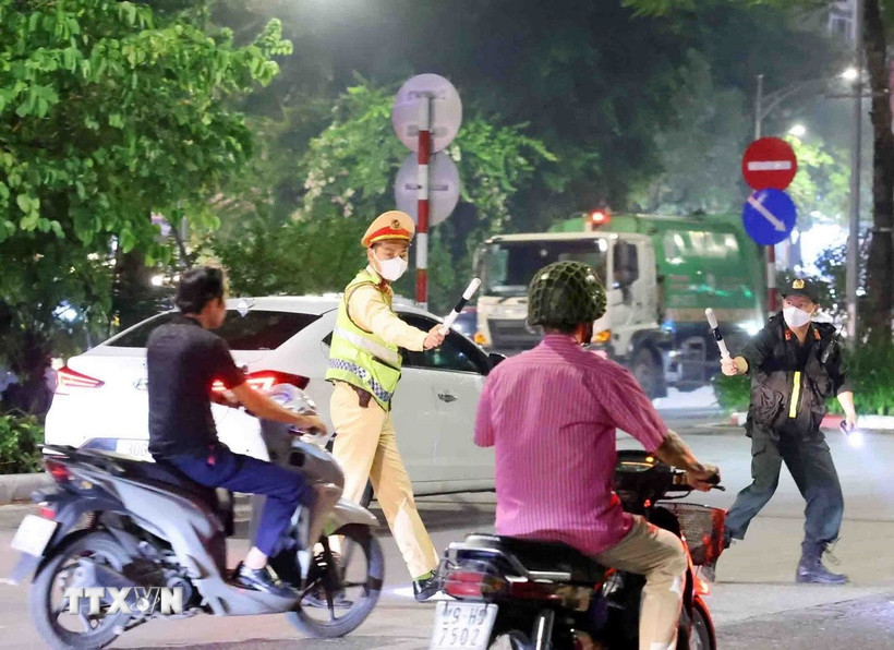 Cán bộ, chiến sỹ thuộc tổ công tác liên ngành Y6/141 dừng xe kiểm tra và xử lý 1 trường hợp vi phạm giao thông. (Ảnh: Phạm Kiên/TTXVN)