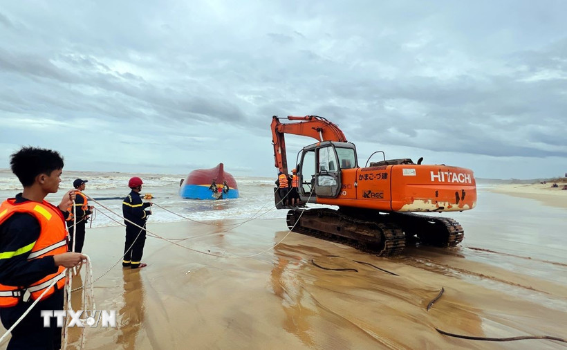 Lực lượng chức năng tỉnh Quảng Trị huy động lực lượng, phương tiện trục vớt tàu BV-92756-TS để tìm kiếm thuyền viên bên trong. (Ảnh: Nguyên Linh/TTXVN)