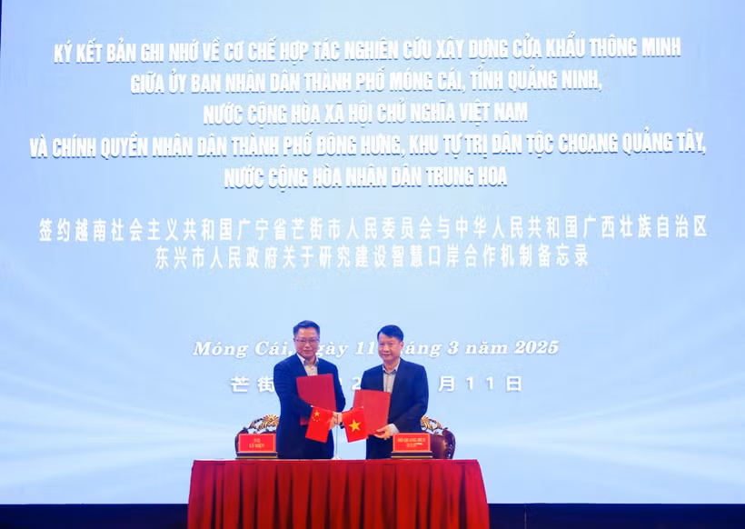 Chủ tịch UBND thành phố Móng Cái (Việt Nam) Hồ Quang Huy và Thị trưởng chính quyền nhân dân thành phố Đông Hưng (Trung Quốc) Lý Kiện trao đổi các nội dung thúc đẩy hợp tác hữu nghị và ký kết Bản ghi nhớ. (Ảnh: Lệ Hằng/TTXVN phát)