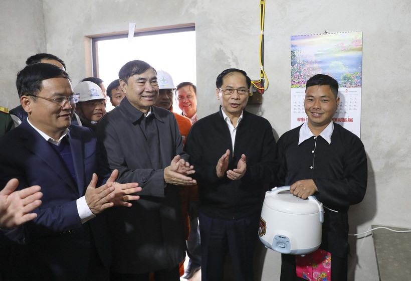 Phó Thủ tướng, Bộ trưởng Ngoại giao Bùi Thanh Sơn cùng lãnh đạo tỉnh Điện Biên tặng nồi cơm điện cho người dân bản Nặm Cứm, xã Ngối Cáy. (Ảnh: Xuân Tư/TTXVN)