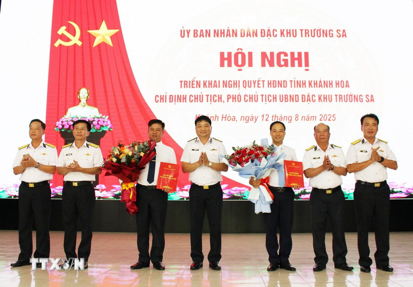 Thượng tá Bùi Xuân Bình, Bí thư Đảng ủy, Chính ủy Vùng 4 Hải quân (giữa) trao Nghị quyết của Thường trực Hội đồng Nhân dân tỉnh Khánh Hòa về việc chỉ định Chủ tịch, Phó Chủ tịch Ủy ban Nhân dân Đặc khu Trường Sa nhiệm kỳ 2021-2026. (Ảnh: TTXVN phát)