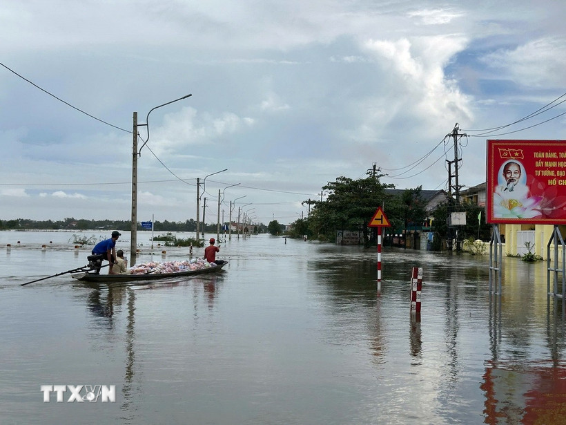Các đoàn tình nguyện vận chuyển hàng hóa lên ghe để đưa vào những vùng ngập sâu ở thành phố Huế. (Ảnh: Đỗ Trưởng/TTXVN)