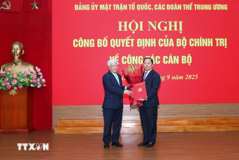 Ông Đỗ Văn Chiến trao quyết định cho ông Nguyễn Phi Long, Ủy viên dự khuyết Trung ương Đảng, Phó Bí thư Đảng ủy Mặt trận Tổ quốc, các đoàn thể Trung ương. (Ảnh: TTXVN phát)