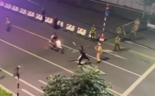 Nguyễn Bá Hoài Nam lái xe máy chở theo Nguyễn Văn Quân "thông chốt," lao thẳng vào đại úy Lê Đình Công. (Ảnh chụp màn hình)