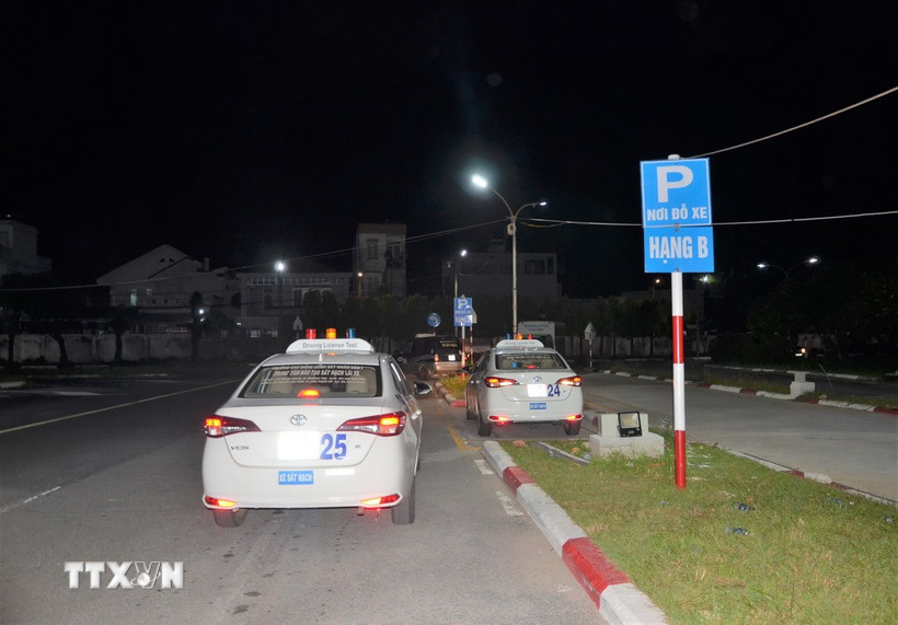 Các học viên thực hành phần thi nội dung sa hình tại một trung tâm sát hạch lái xe tối 29/7. (Ảnh: Linh Sơn/TTXVN)