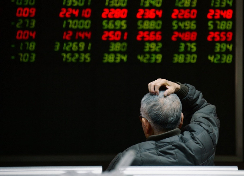 Nhà đầu tư theo dõi bảng chỉ số chứng khoán tại Bắc Kinh, Trung Quốc. (Ảnh: AFP/TTXVN)