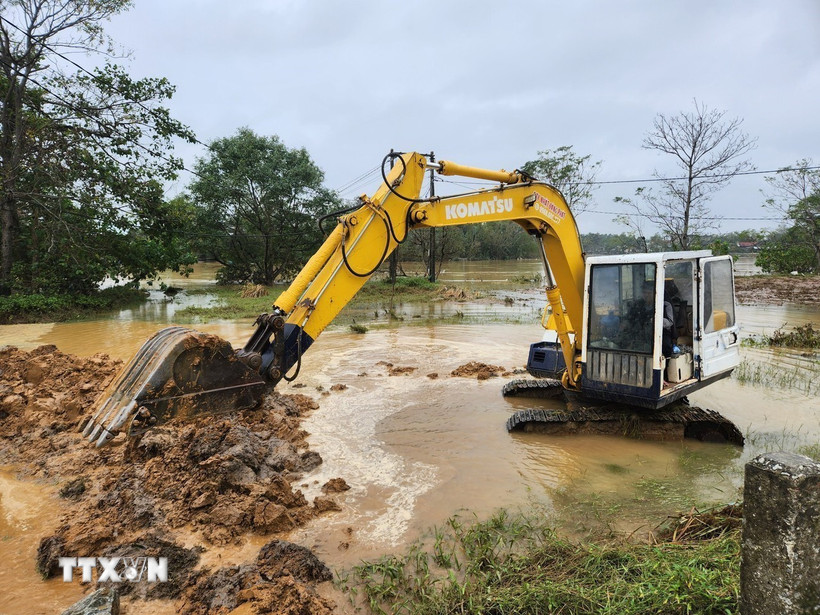 Đắp đất làm đê tạm, ngăn dòng nước chảy xiết tiếp tục gây xói lở phần đất, đá gia cố trên đoạn đê. (Ảnh: Mai Trang/TTXVN)