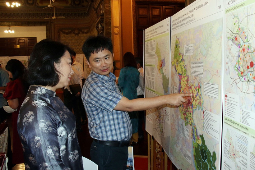 Các đại biểu theo dõi bản đồ quy hoạch Thành phố Hồ Chí Minh. (Ảnh: Tiến Lực/TTXVN)