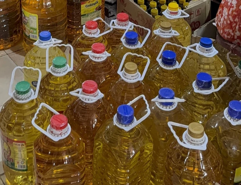 Dầu ăn giá rẻ được bày bán tràn lan tại các chợ đầu mối. (Ảnh: Sĩ Dũng/Vietnam+)