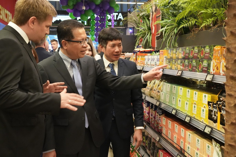 Đại sứ Đặng Minh Khôi (giữa) đi thăm các kệ trưng bày hàng Việt Nam. (Ảnh: Quang Vinh/TTXVN)