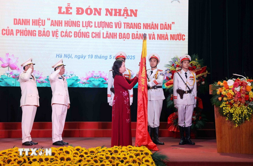 Phó Chủ tịch nước Võ Thị Ánh Xuân gắn huy hiệu “Anh hùng Lực lượng Vũ trang Nhân dân” lên lá cờ truyền thống Phòng Bảo vệ các đồng chí Lãnh đạo Đảng và Nhà nước thuộc Bộ Tư lệnh Cảnh vệ, Bộ Công an. (Ảnh: Phạm Kiên/TTXVN)
