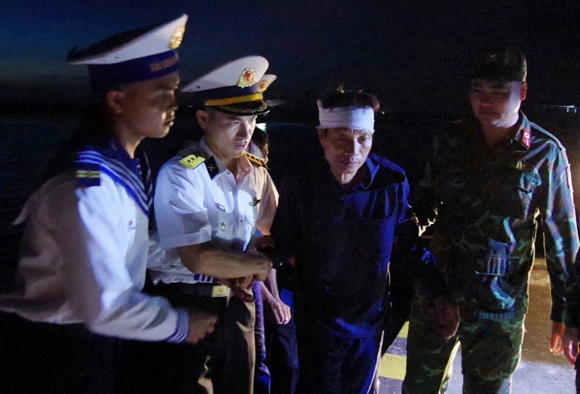 Các chiến sỹ đảo Trường Sa dìu bệnh nhân Tiêu Viết Bút đến Trung tâm y tế. (Ảnh: TTXVN phát)