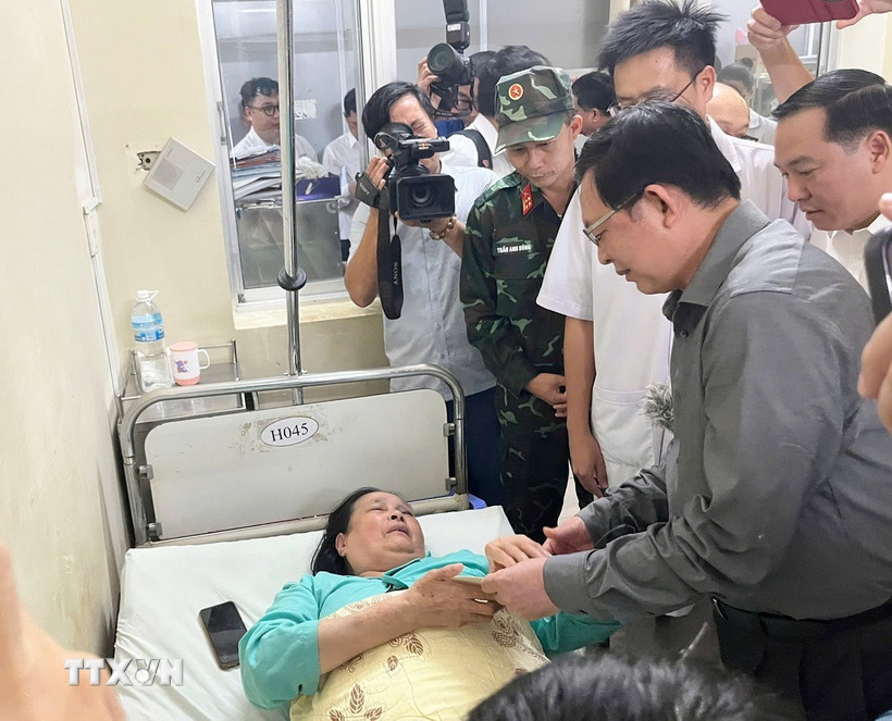 Thay mặt Chính phủ, Phó Thủ tướng Hồ Quốc Dũng tặng quà động viên nạn nhân vụ trong vụ sạt lở đèo Khánh Lê. (Ảnh: Phan Sáu/TTXVN)