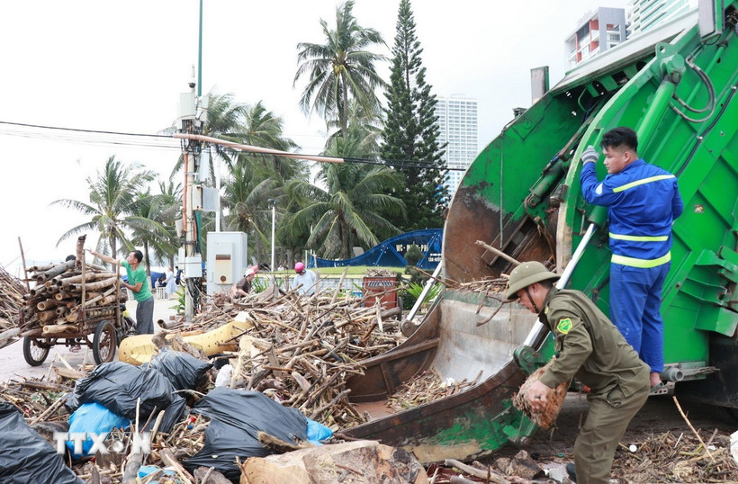 Xe thu gom rác và công nhân vệ sinh môi trường từ thành phố Hồ Chí Minh đến Khánh Hòa hỗ trợ thu gom rác trên bãi biển Nha Trang. (Ảnh: Phan Sáu/TTXVN)