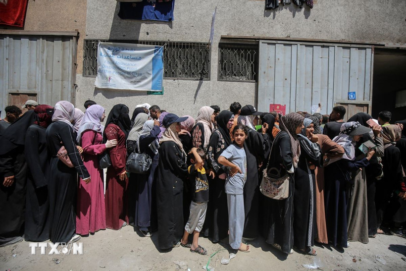 Người dân Palestine tập trung tại một điểm phân phát hàng cứu trợ ở Gaza. (Ảnh: THX/TTXVN)
