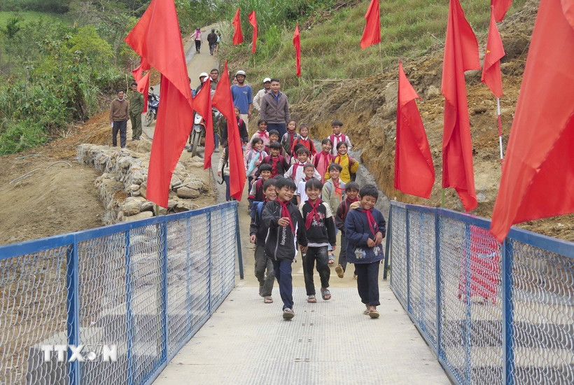 Học sinh tại 5 thôn bị cô lập qua cầu để đến trường an toàn. (Ảnh: Dư Toán/TTXVN)