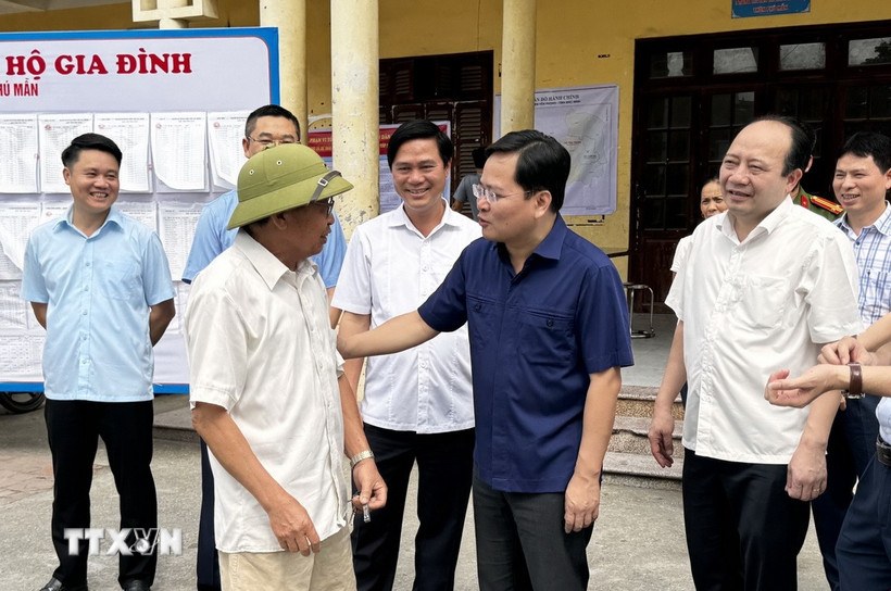 Bí thư Tỉnh ủy Bắc Ninh Nguyễn Anh Tuấn (áo xanh than) động viên người dân tại điểm lấy ý kiến đề án sáp nhập. (Ảnh: Thái Hùng/TTXVN)