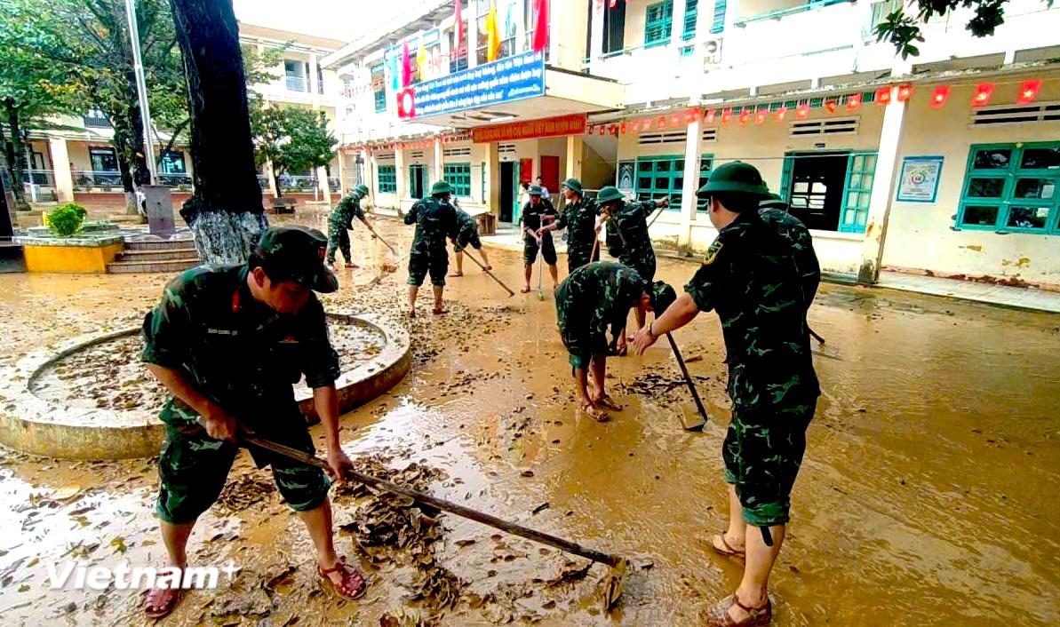 Cán bộ, chiến sỹ Cục Hậu cần - Kỹ thuật Quân khu 5 hỗ trợ một trong tiểu học trên địa bàn xã Nông Sơn dọn bùn non sau khi nước rút. (Ảnh: PV/Vietnam+)