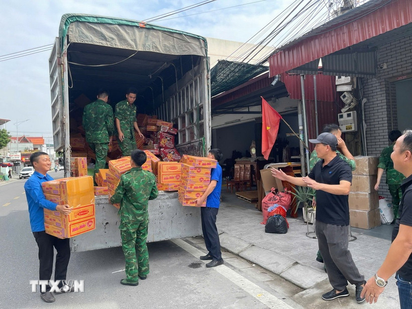 Các thùng mỳ tôm được vận chuyển lên xe ủng hộ người dân vùng lũ miền Trung. (Ảnh: Tiến Vĩnh/TTXVN)