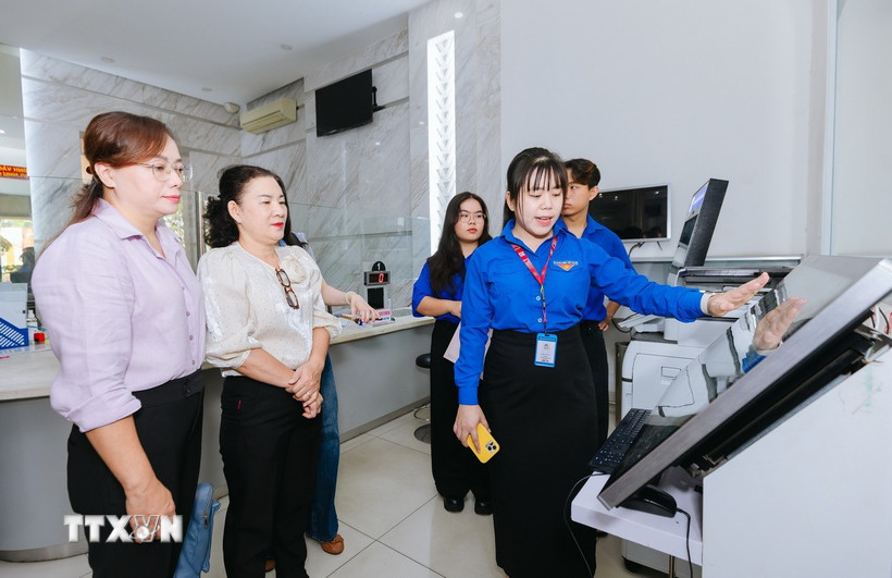 Đoàn viên thanh niên hướng dẫn người dân thực hiện các thủ tục hành chính tại Trung tâm phục vụ hành chính công phường Sài Gòn. (Ảnh: Thu Hương/TTXVN)
