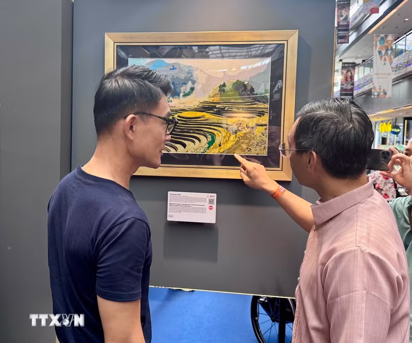 Đại sứ Trần Phước Anh (phải) giới thiệu tranh của Việt Nam với ông Baey Yam Keng - Quận trưởng quận Đông Bắc. (Ảnh: Đỗ Vân/TTXVN)