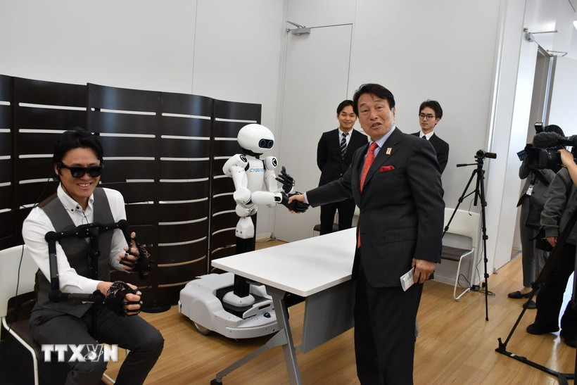 Robot từ xa hoạt động đồng bộ với chuyển động của robot chính trong động tác bắt tay với Tổng giám đốc điều hành Tập đoàn Pasona. (Ảnh: Nguyễn Tuyến/TTXVN)