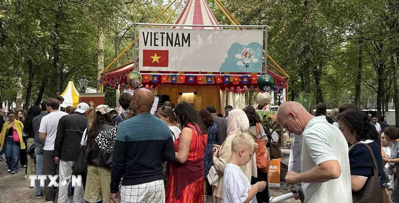 Du khách xếp hàng để thưởng thức món phở tại gian hàng của We love Phở. (Ảnh: TTXVN phát)