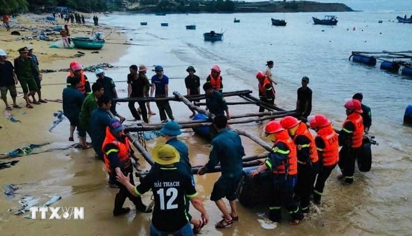 Lực lượng vũ trang tỉnh Đắk Lắk và chính quyền địa phương giúp dân cẩu kéo các tàu, bè nuôi trồng thủy sản lên khu vực an toàn. (Ảnh: TTXVN phát)