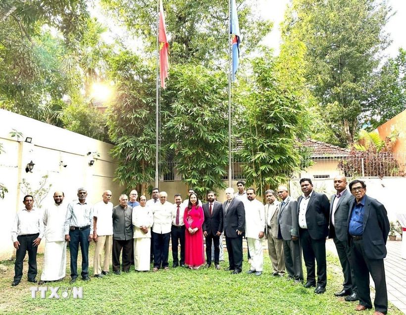 Các đại biểu chụp ảnh lưu niệm tại khuôn viên Đại sứ quán trong kỷ niệm 95 năm Ngày thành lập Đảng. (Ảnh: TTXVN phát)