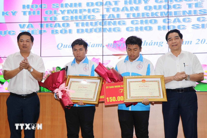 Bí thư Tỉnh ủy Quảng Nam Lương Nguyễn Minh Triết và Chủ tịch Ủy ban Nhân dân tỉnh Quảng Nam Lê Văn Dũng tặng Bằng khen và hoa cho hai anh em Nguyễn Trí Hiền và Nguyễn Trí Hậu. (Ảnh: Đoàn Hữu Trung/TTXVN)